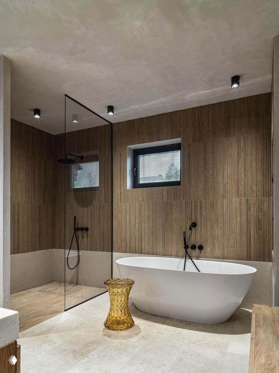 Ванная комната с отдельно стоящей белой ванной, стеклянной душевой перегородкой и деревянной отделкой стен в стоне джапанди и натуральных материалов.