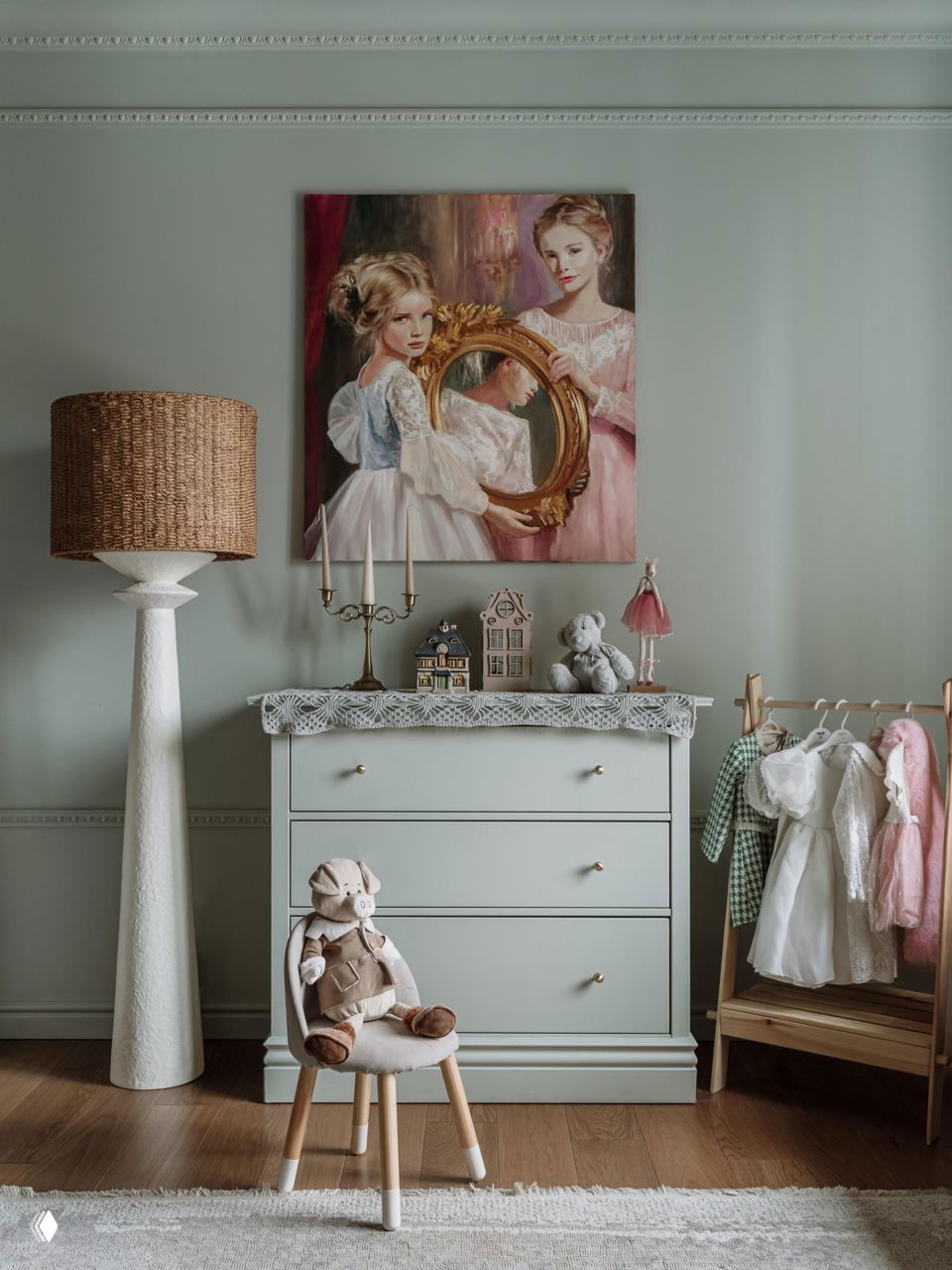 Детская зона: комод с игрушками и картина над ним, мягкие пастельные тона, плетёный торшер и аккуратная организация пространства для ребёнка.