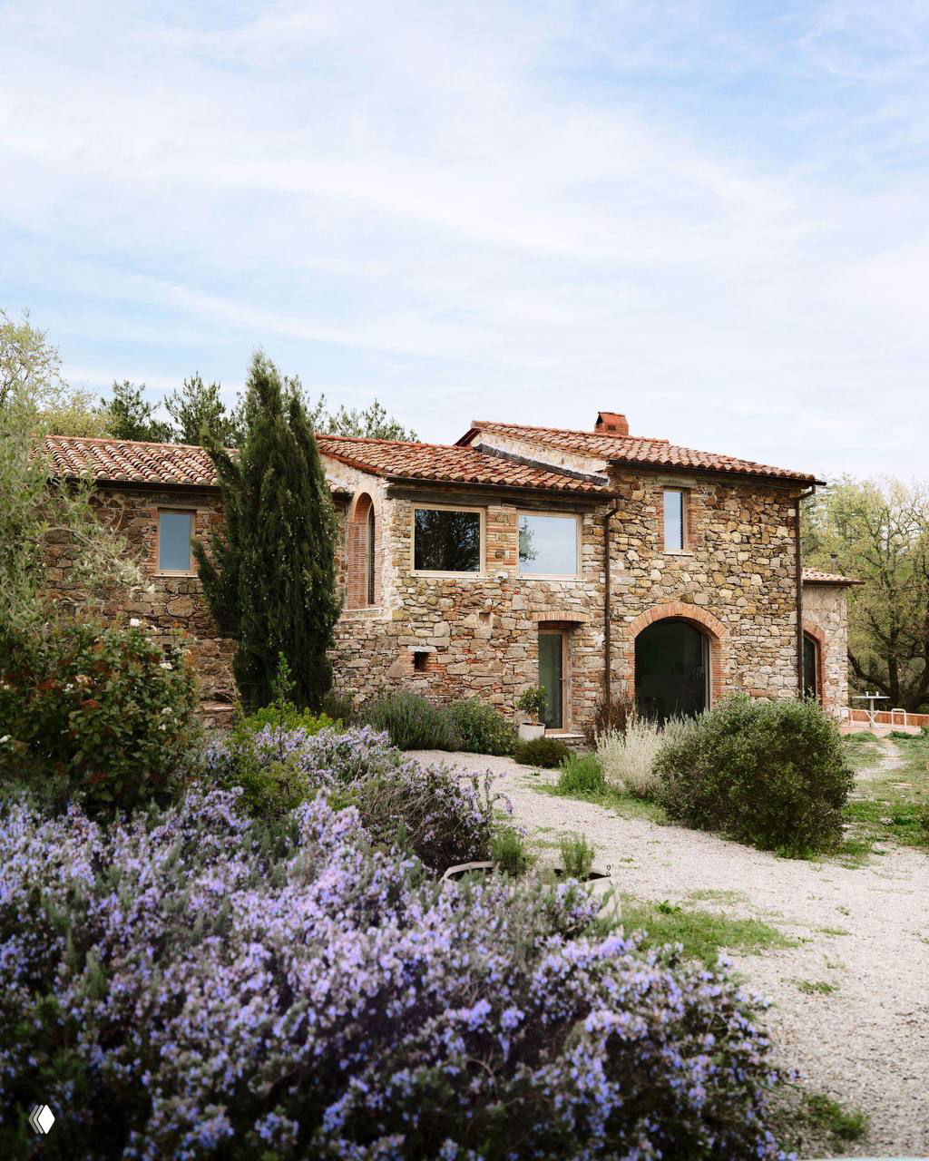 Тосканский дом Гарри Нуриева на фоне лавандового сада: каменная кладка, арочные окна и черепичная крыша в сельском окружении.