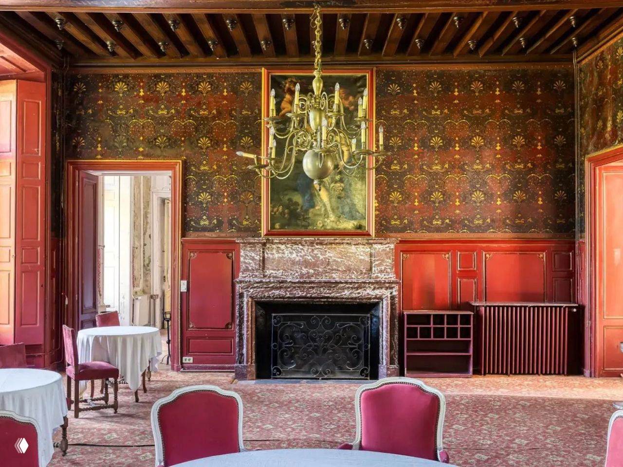 Интерьер замкового банкетного зала: камин из мрамора, росписи на стенах, позолоченная люстра и антикварная мебель для приёмов.