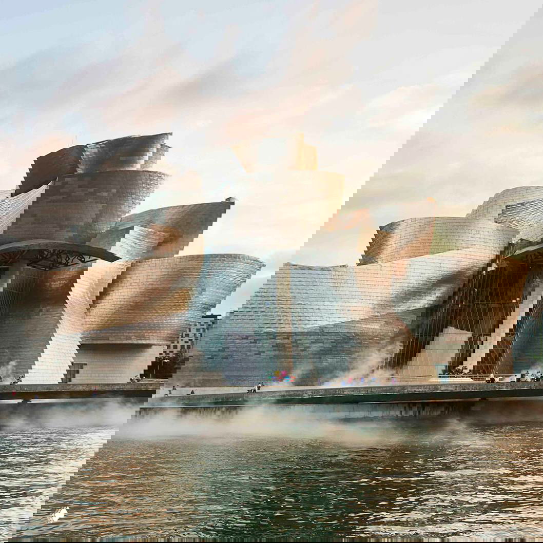 Музей Гуггенхайма в Бильбао на набережной: изогнутые металлические и каменные формы, визитная карточка творчества Фрэнка Гери.