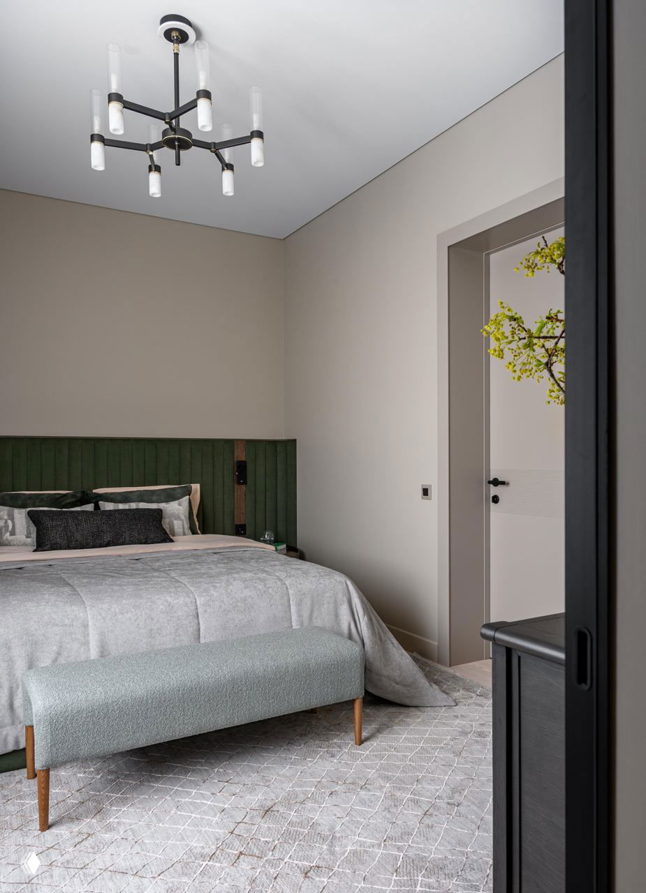 Спальня с приглушёнными тонами, зелёное изголовье и мягкая серая постель; пример использования контрастного текстиля в персональной зоне.