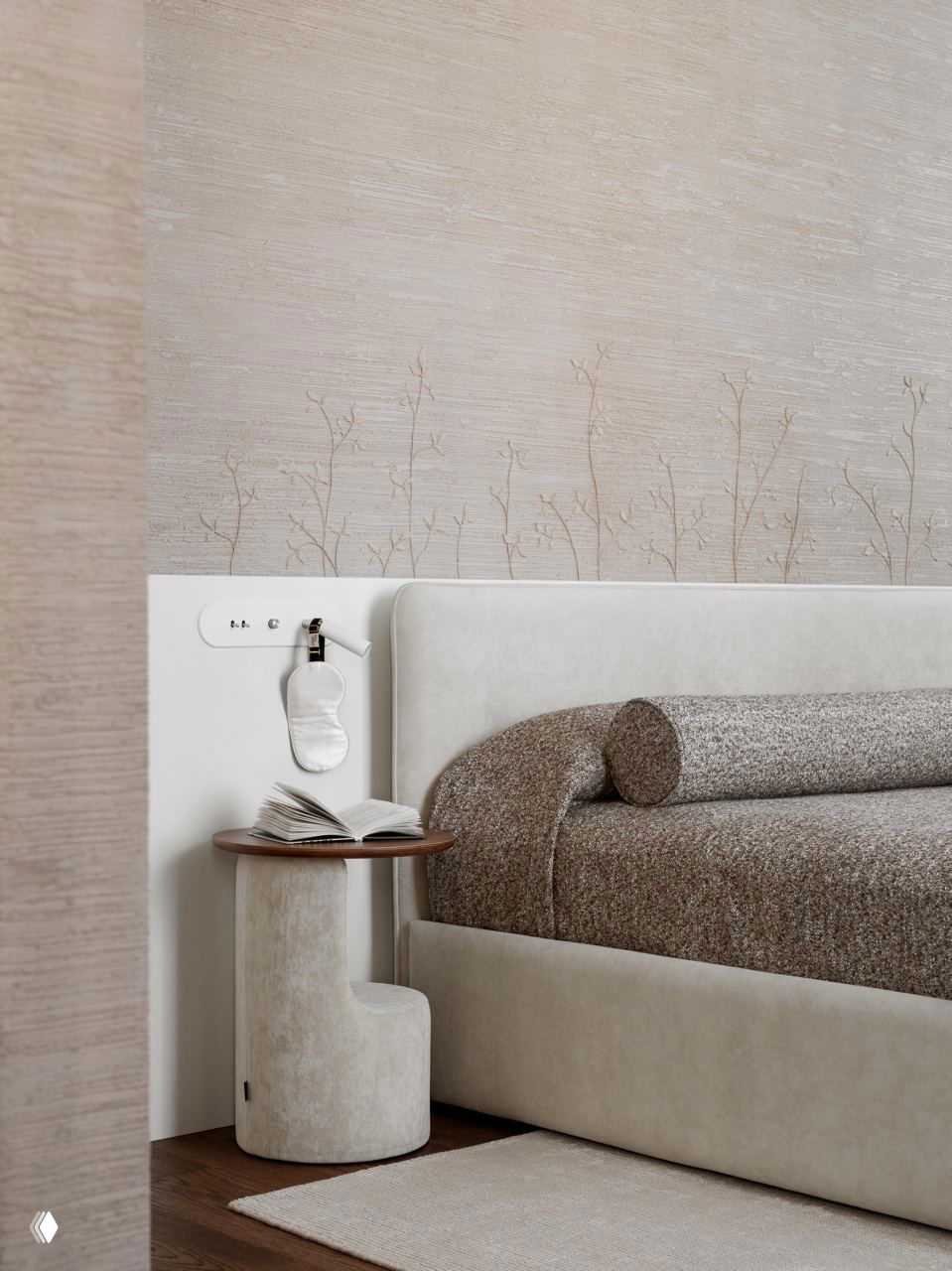 Деталь спальни: прикроватная зона с текстурными обоями с растительным орнаментом, бежевые фактуры и аккуратная прикроватная тумба.