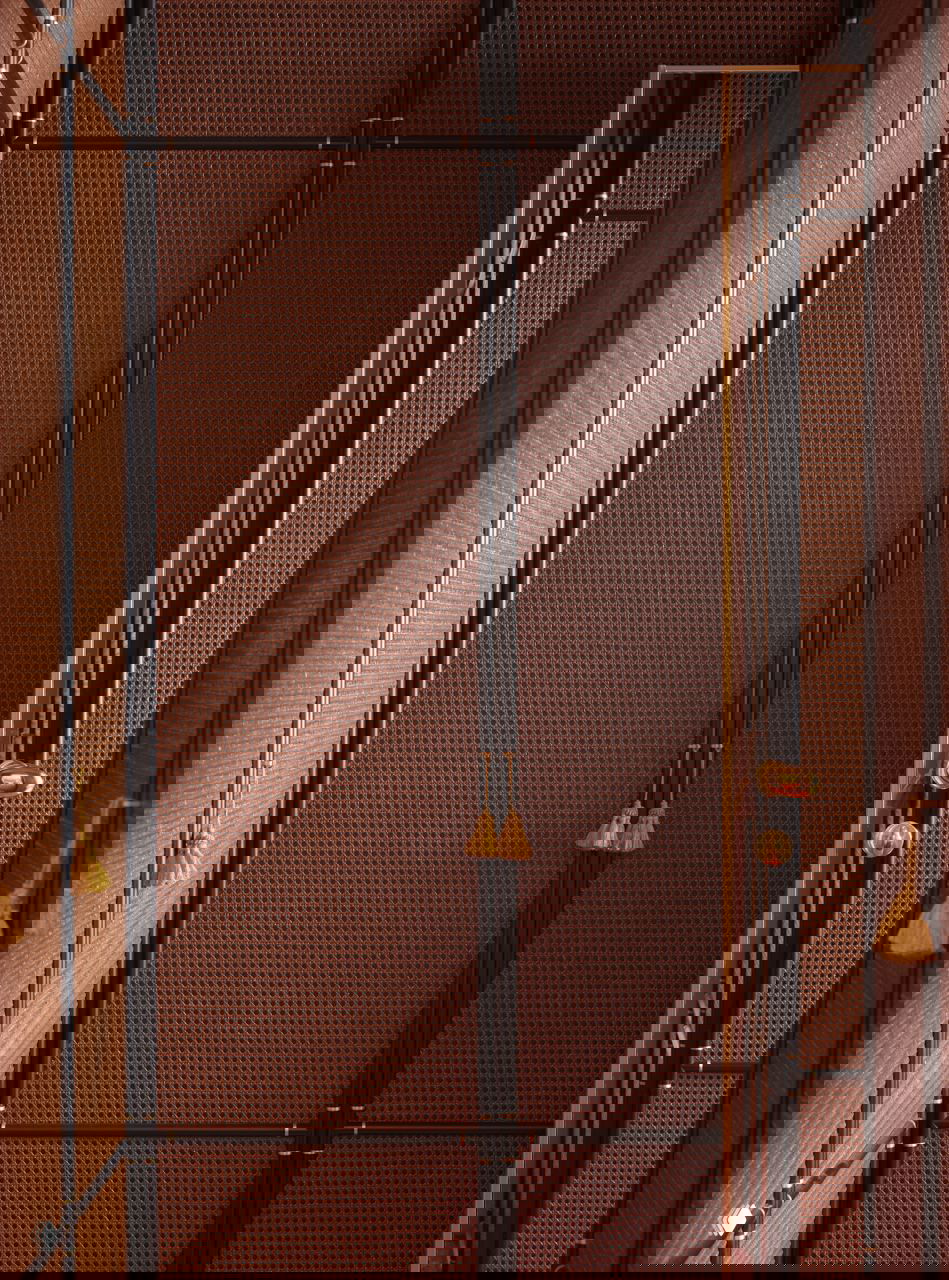 Дверные и стеновые панели в тёплых кирпичных тонах с плетёной структурой и кисточками на ручках — пример использования текстур и мастерской отделки в квартире Dimorestudio.