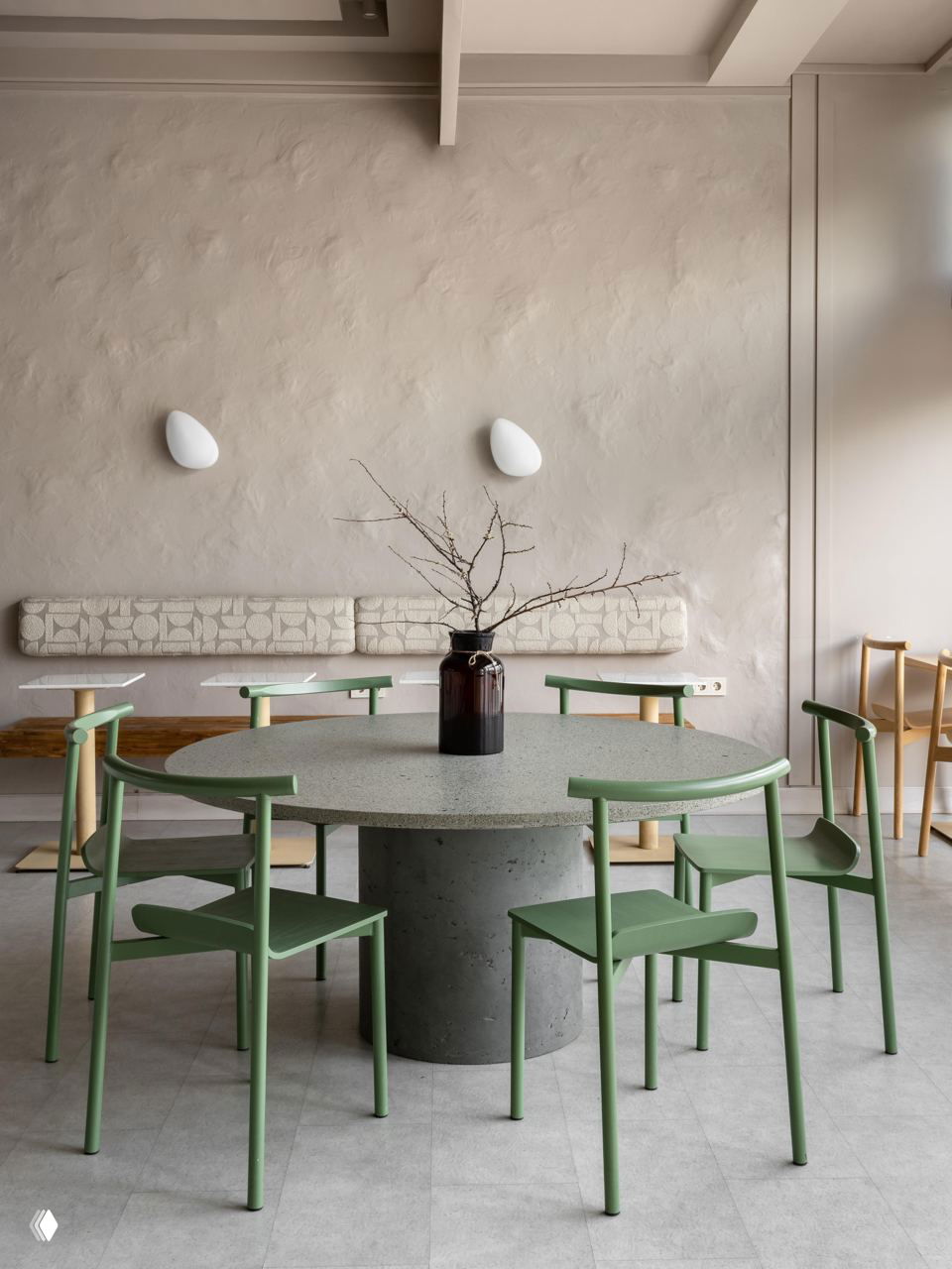 Текстурная штукатурка на стене, мягкая банкетка и круглый стол — гипсовые панели и объёмные формы создают живописный фон интерьера.