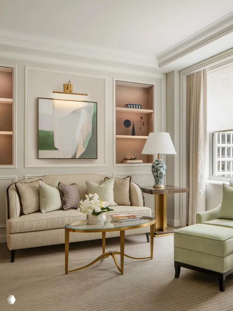 Классический гостиничный номер в нейтральных тонах: диван, столик, кресло и большое окно — современный комфорт внутри исторического здания.