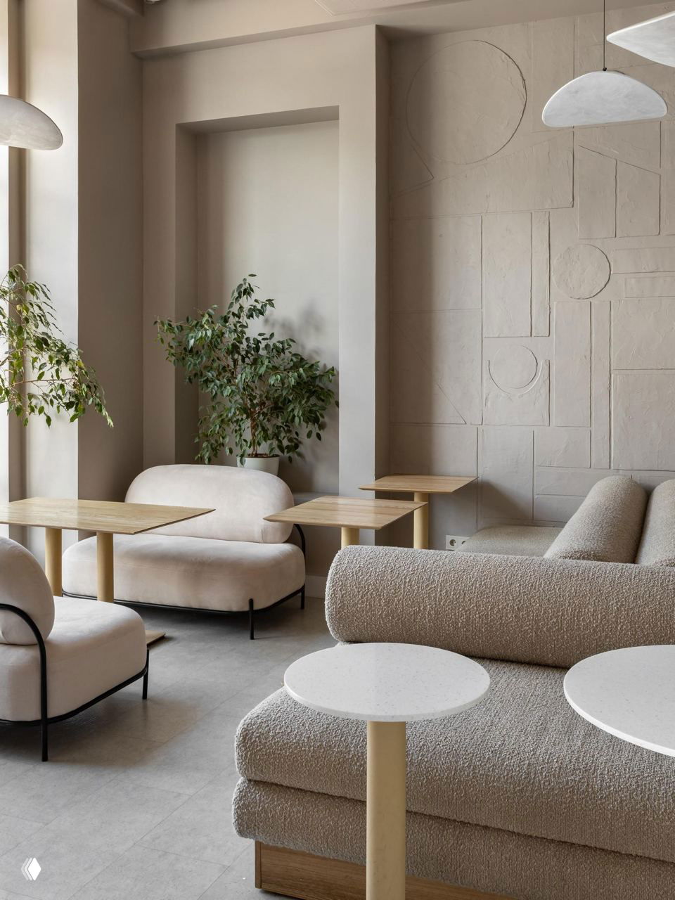 Мягкие диваны и декоративные подвесные панели с геометрией: сочетание текстур и нейтральных оттенков усиливает ощущение уюта и объёма.