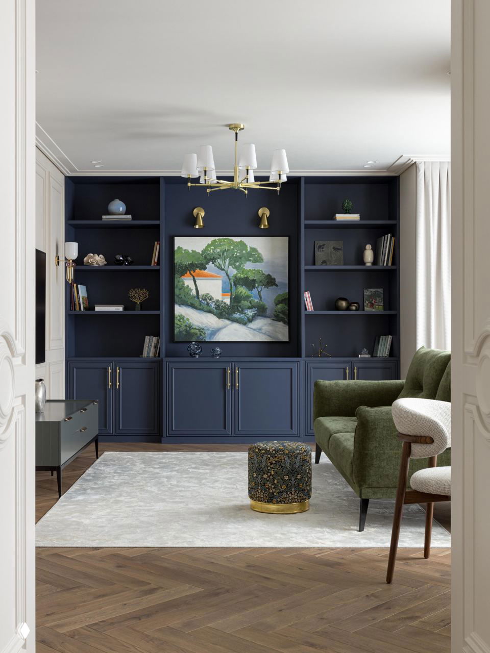 Гостиная с тёмно-синим встроенным шкафом, декоративной картиной и зелёным диваном — пример цветных акцентов в интерьере современной классики 125 м².