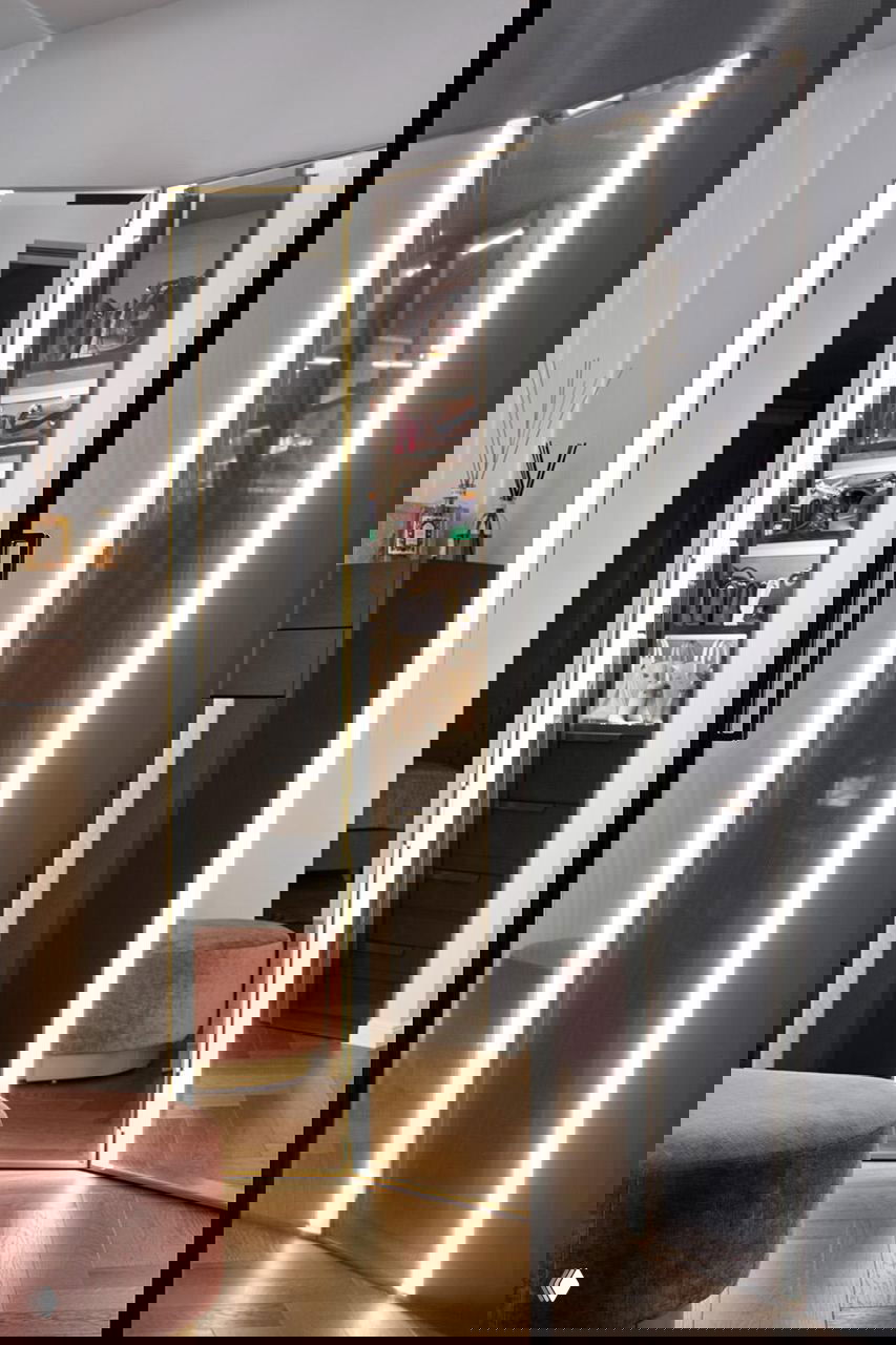 Гардеробная/зона макияжа с зеркальной складной перегородкой, встроенной подсветкой по периметру, бархатными пуфами и деревянным паркетом — элегантная часть квартиры.