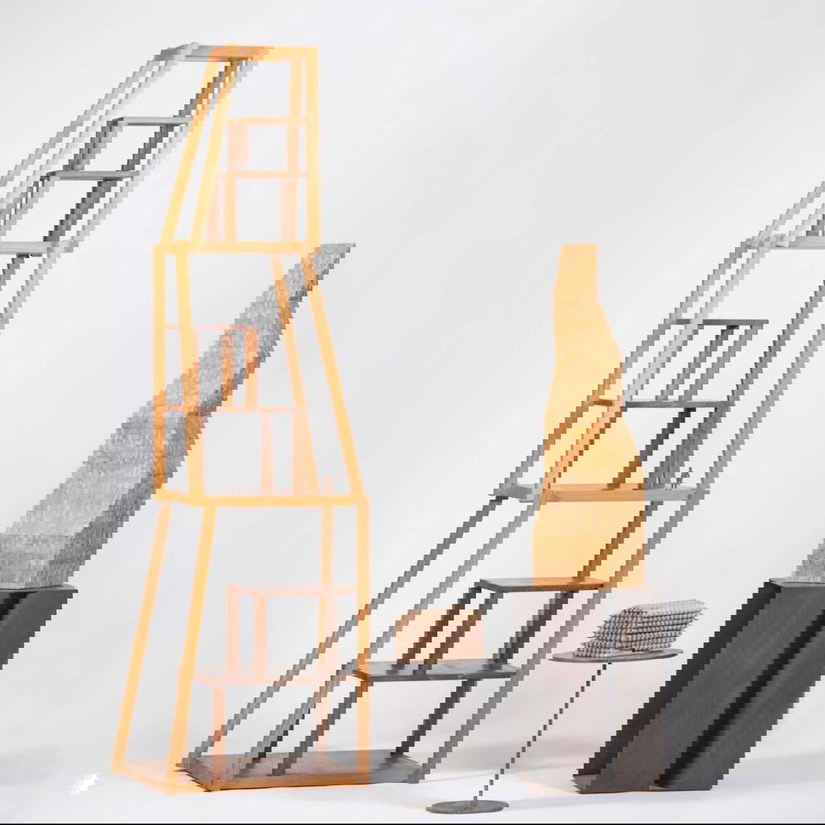 Деревянные мебельные объекты и скульптуры Микеле де Лукки на белом фоне: ступенчатая этажерка и абстрактная колонна в студийной съемке.