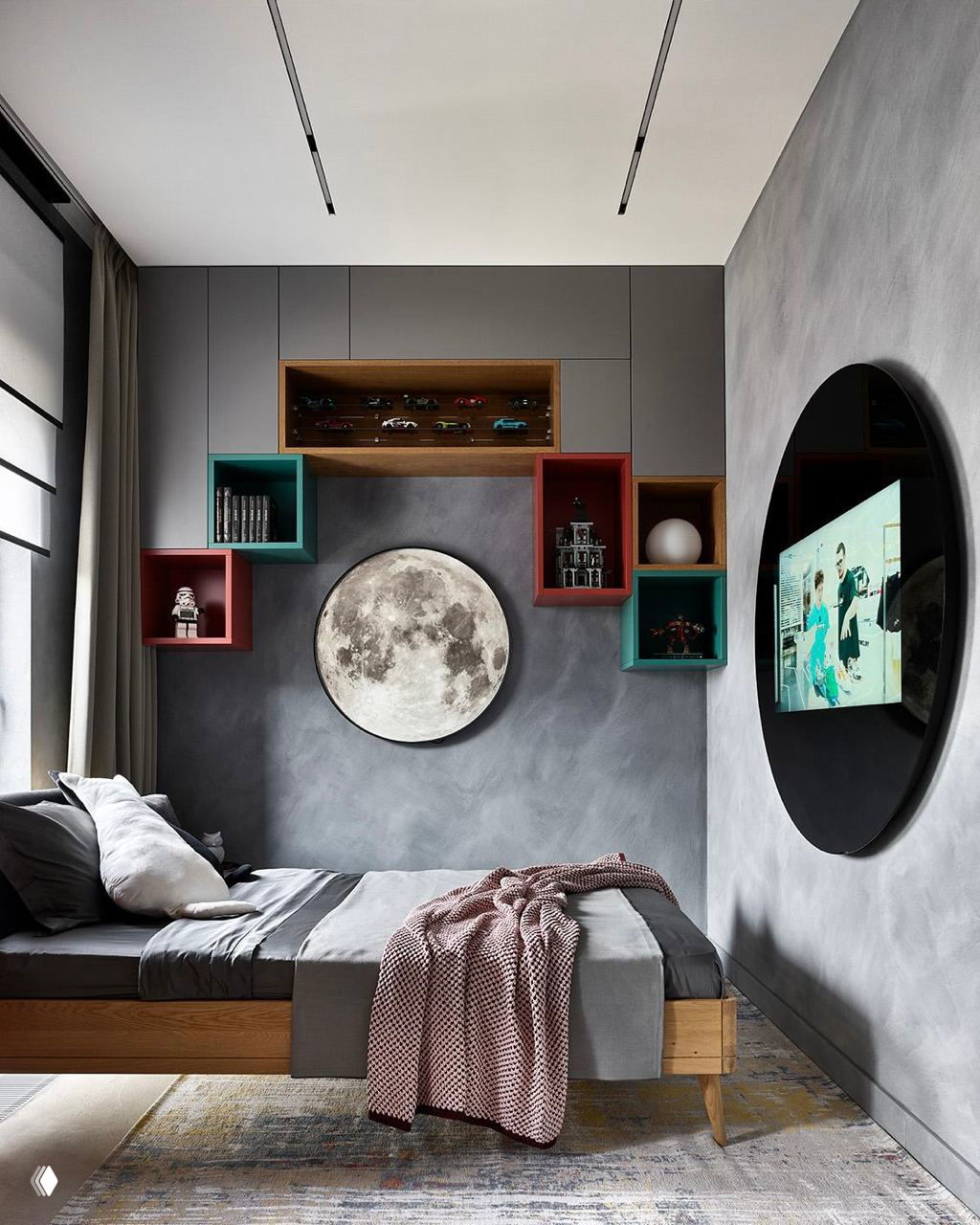 Темная стильная комната подростка с серыми стенами, деревянной кроватью, круглыми нишами и большой декоративной луной над изголовьем.
