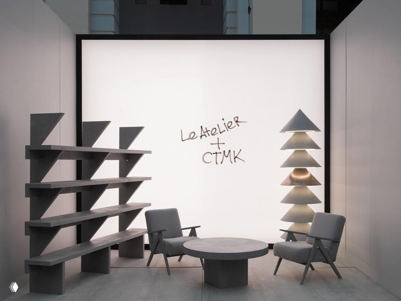 Экспозиция коллекции «Уют» Le Atelier: журнальный стол, книжный стеллаж, кресла и скульптурный светильник с фактурой микробетона в нейтральной палитре