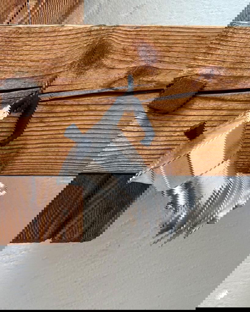 Кофеварка Turbo Moka висит на деревянной перекладине в кухонной обстановке, на ней видна турбинная спиральная юбка и алюминиевый корпус.