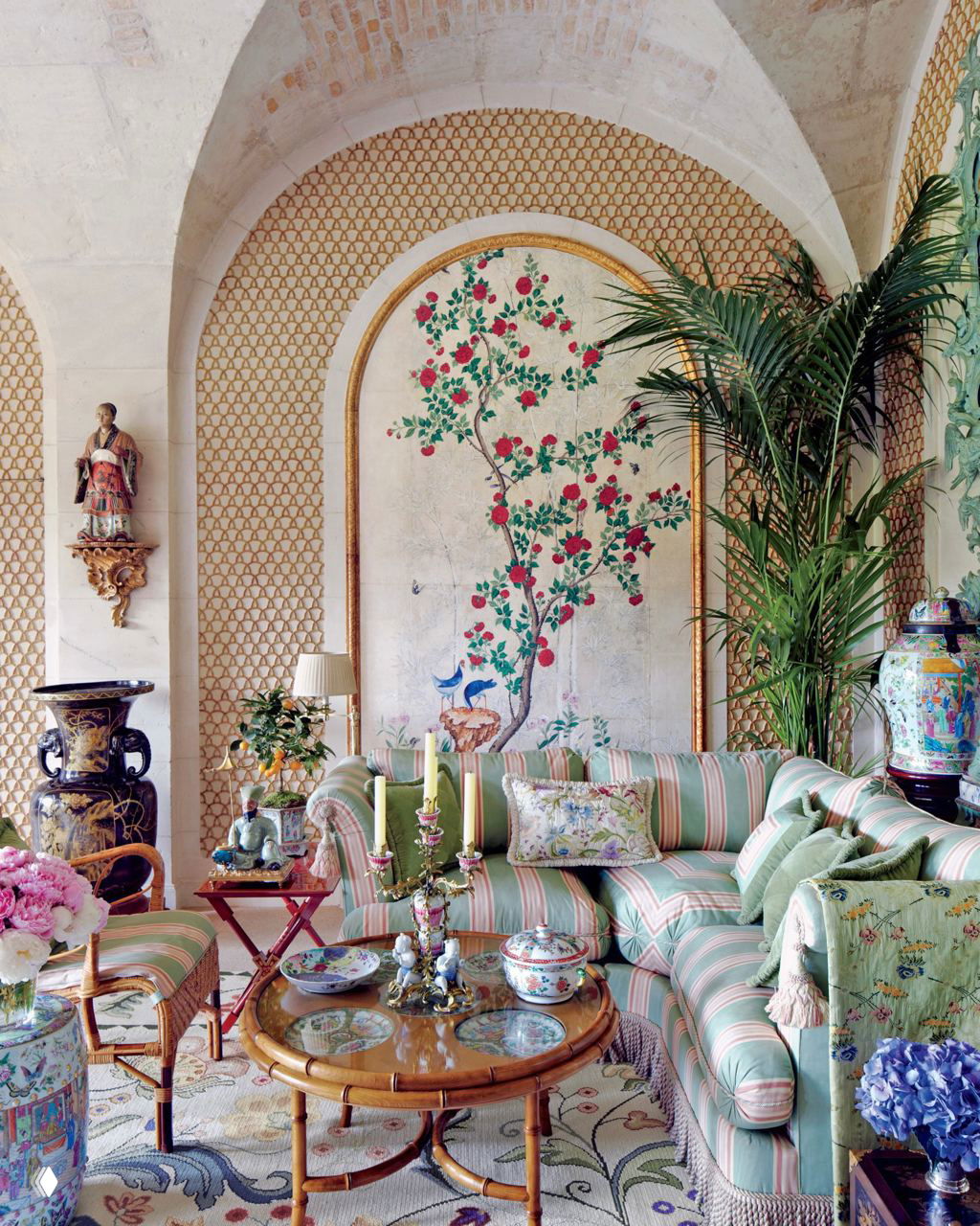 Светлый салон с арочными сводами, диваном в полоску, декоративными китайскими вазами и круглым кофейным столиком с фарфоровыми предметами.