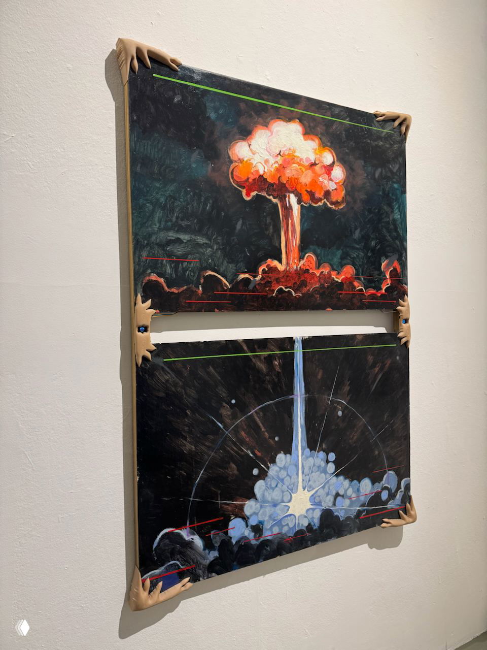 Инсталляция на выставке: две картины одна над другой с образами взрыва и вспышки, обрамлённые декоративными моделями рук на стене галереи