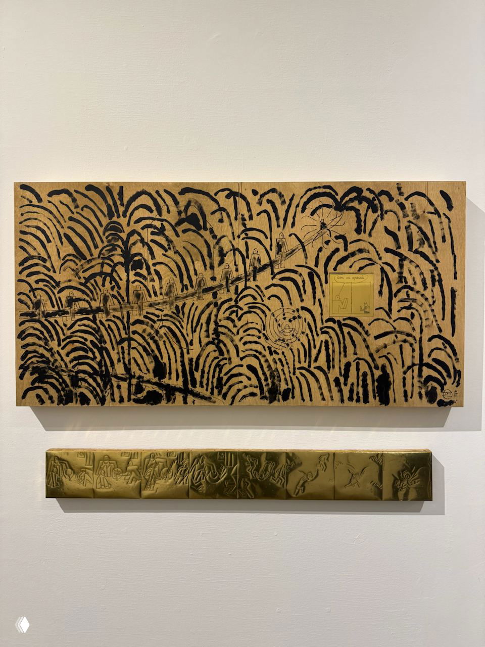 Панно на стене галереи с чёрно-золотистыми графическими штрихами и волнообразным узором, под ним узкая золотистая барельефная полоса