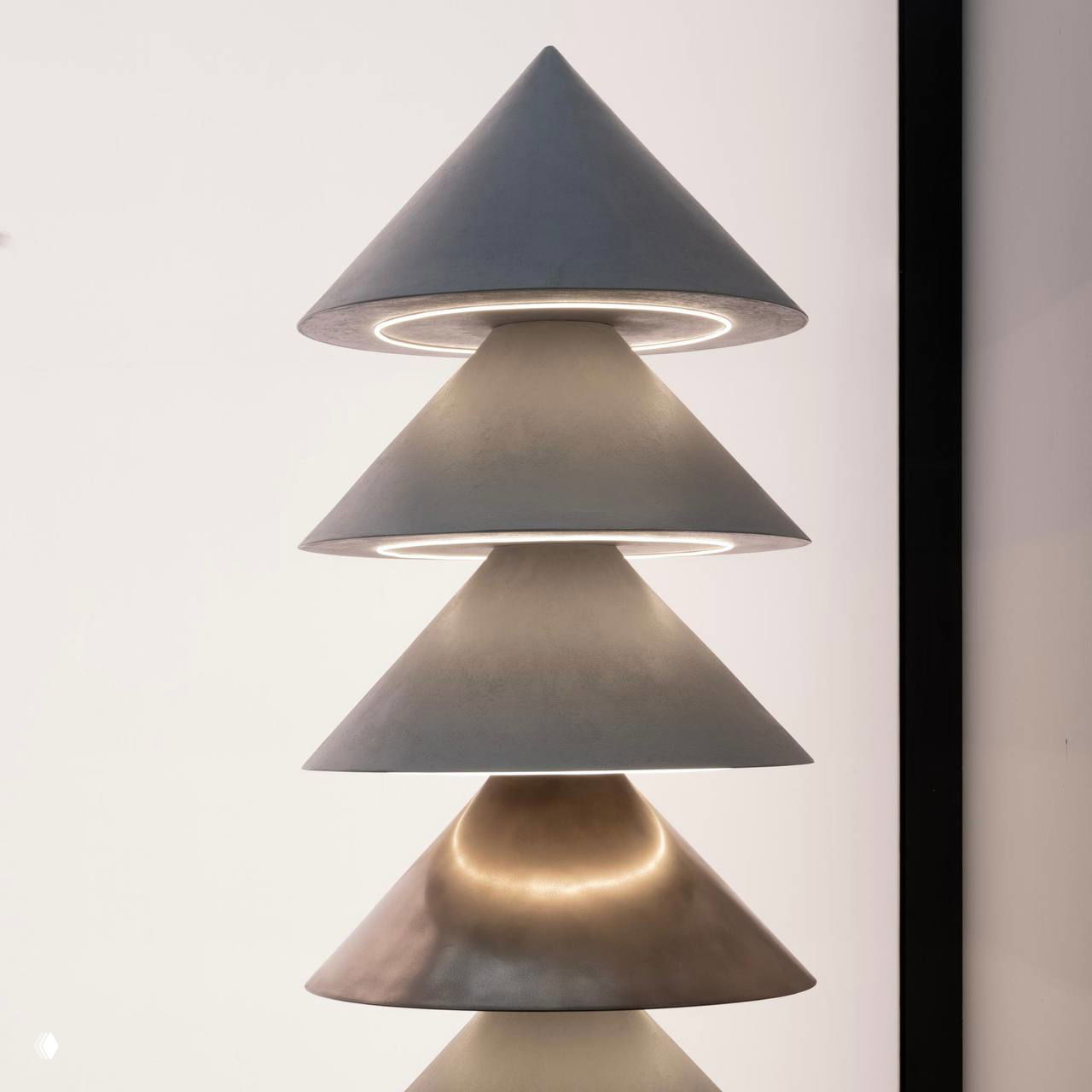 Скульптурный светильник из серии «Уют» Le Atelier: пирамидальные конусы, подсветка между слоями и поверхность с эффектом микробетона в студийной подсветке