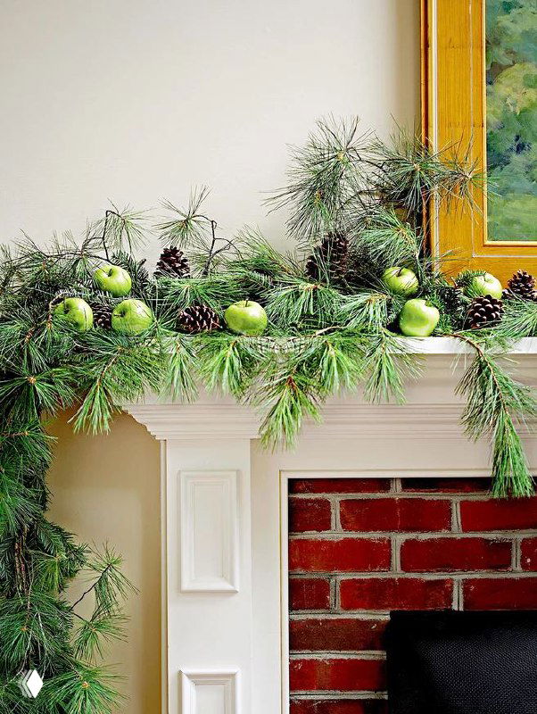 Фрагмент праздничного декора с зелёными ветвями и шарами, изображение частично содержит цифровые артефакты, видна декоративная гирлянда над каминной полкой.