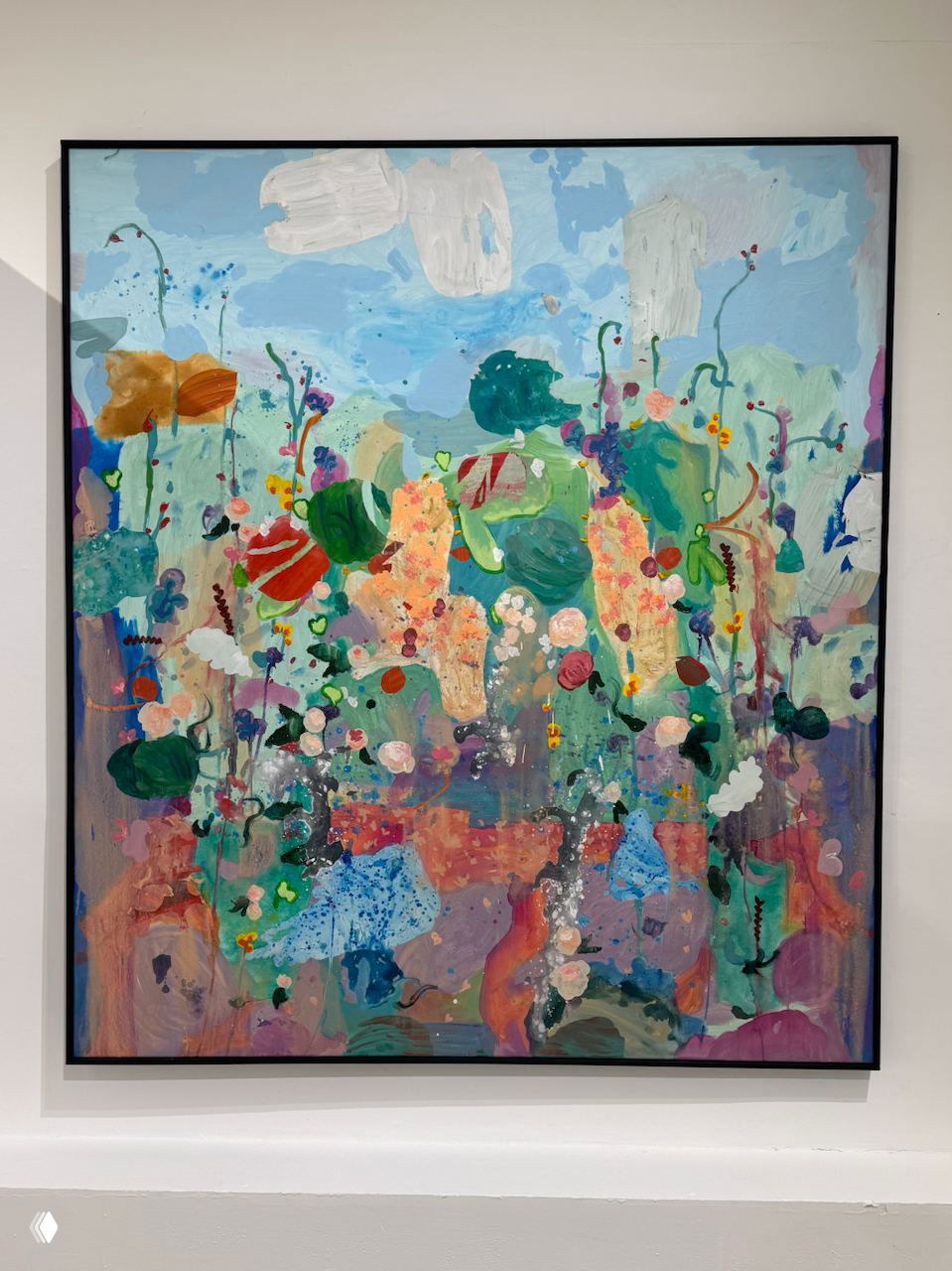 Большая цветная живописная картина в раме с яркими абстрактными цветовыми пятнами и растительными мотивами, представлена на белой стене галереи