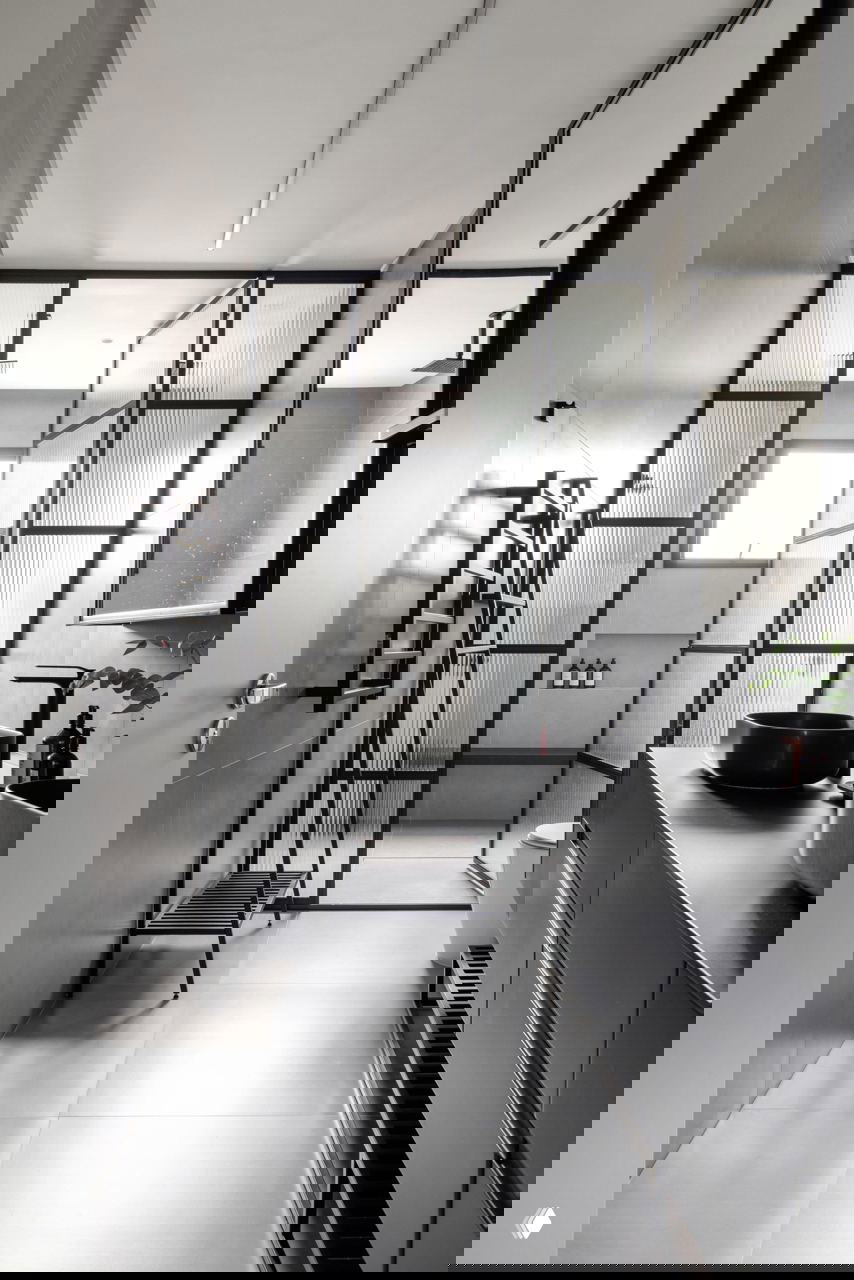 Современная ванная комната в индустриальном стиле: чёрные стальные рамы душевой перегородки, тёмная мебель и минималистичные аксессуары.