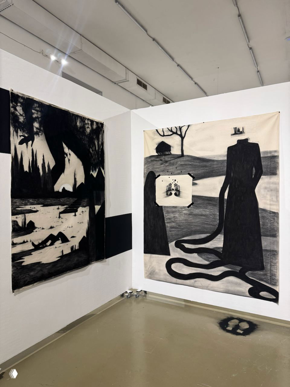 Чёрно-белые большие графические полотна в углу зала: тёмные силуэты и ландшафт, фотография экспозиции в ЦСИ Винзавод