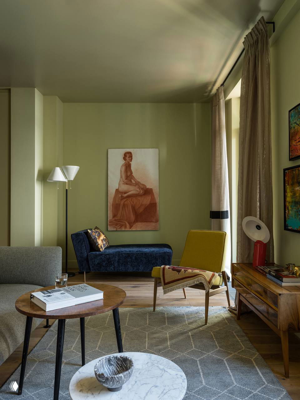 Уютная жилая зона с оливковой окраской стен, сочетание современных и ретро-мебелей, текстурированные ковры и художественные картины на стенах.