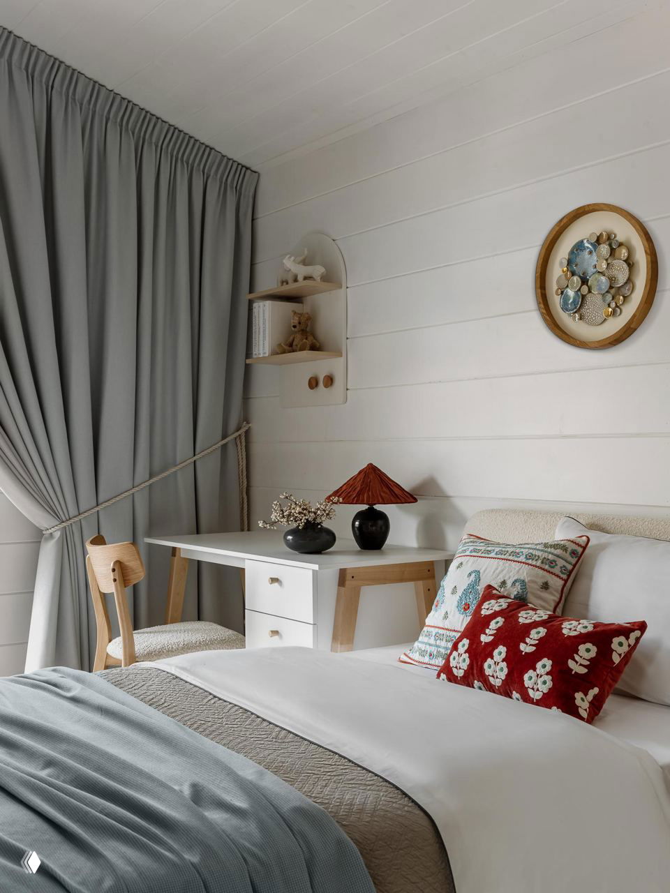 Комната с рабочим столом у окна, светлым текстилем и декоративными подушками — уютное пространство для ребенка или гостевой комнаты в деревенском стиле.