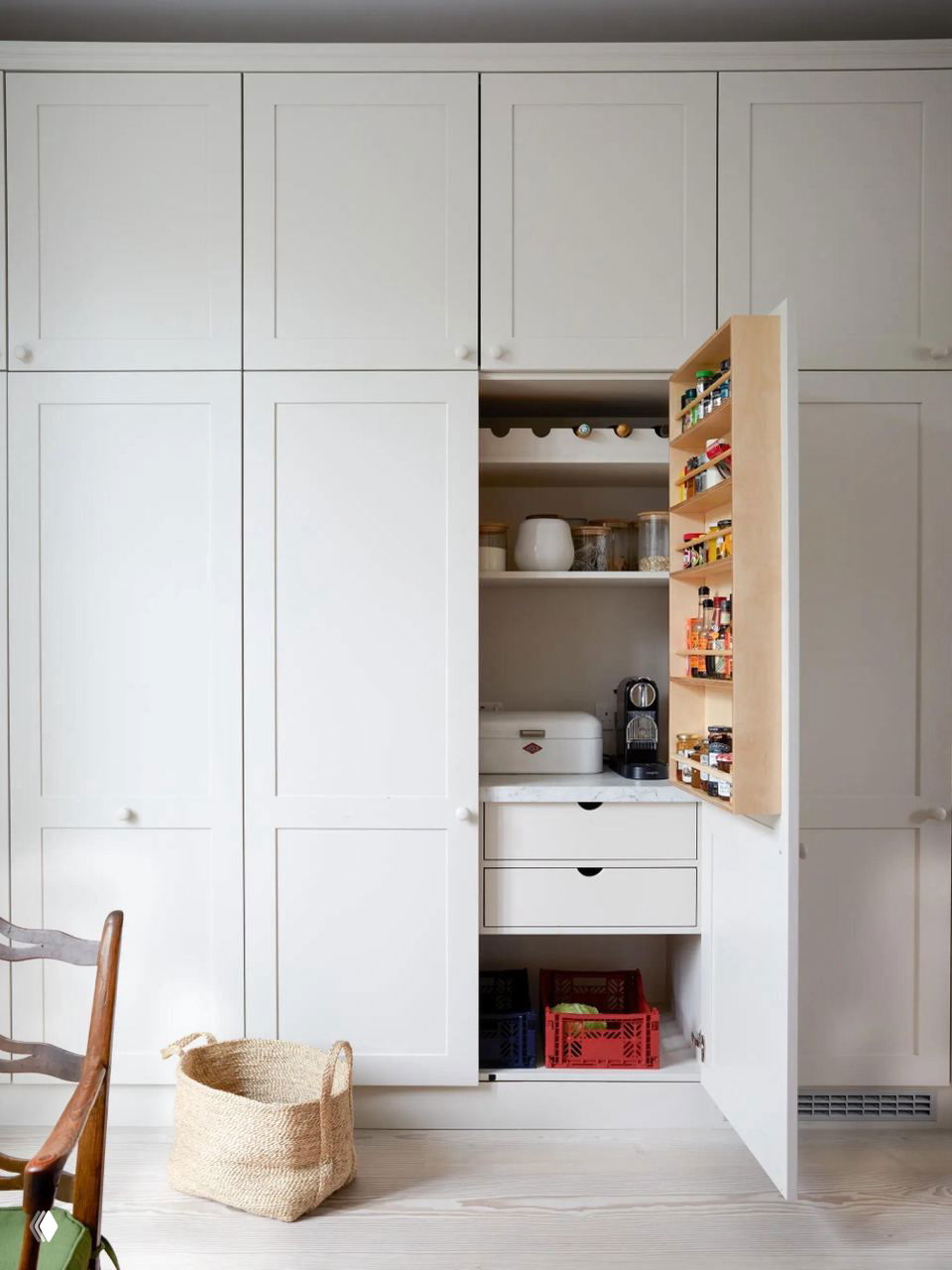Белые встроенные шкафы с выдвижной дверцей-органайзером для специй и бытовой техникой внутри — скрытое хранение при минималистичном оформлении кухни.