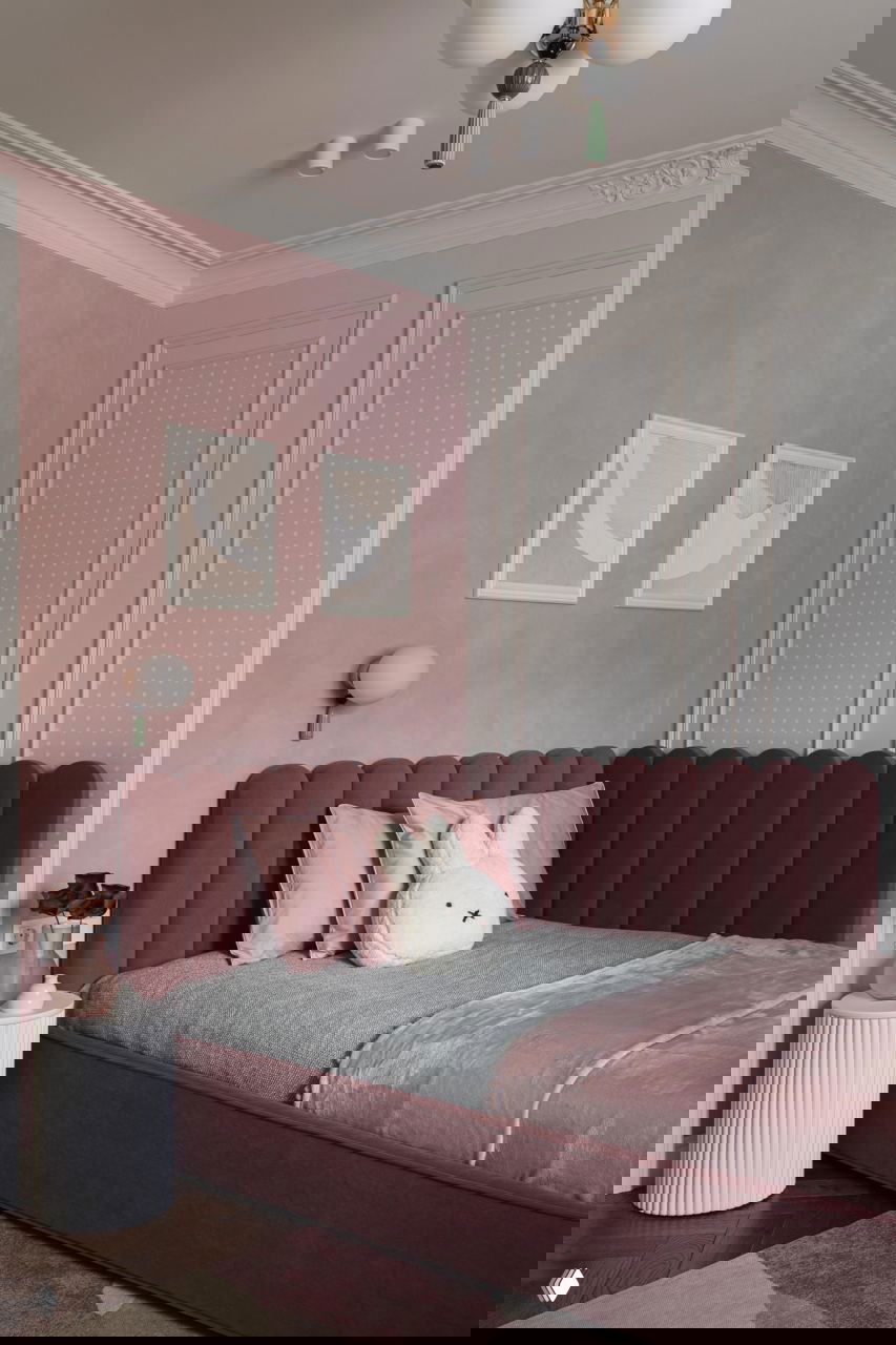 Детская в розово-пастельных тонах: бархатное изголовье кровати, розовые стены и спокойный декоративный текстиль, элементы скандинавского стиля.