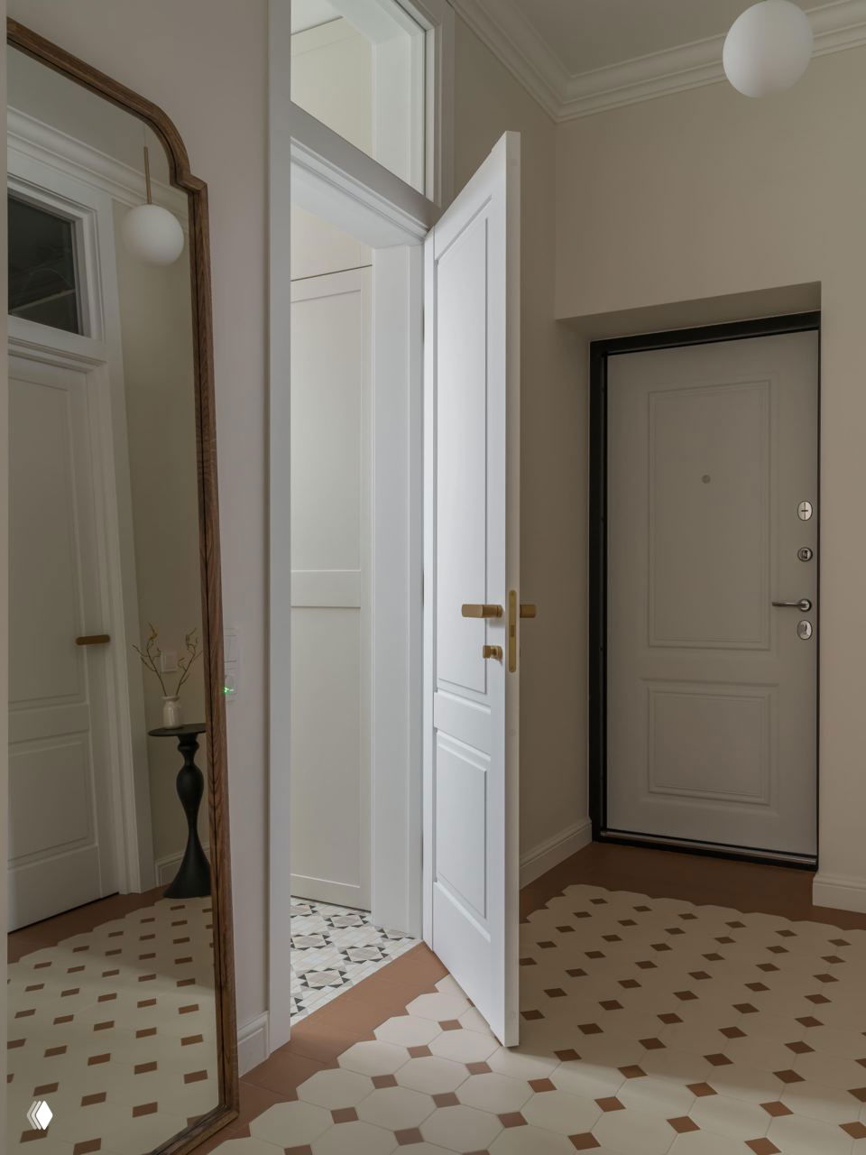 Прихожая с высокими дверями и зеркалом в раме, декоративная мозаичная плитка на полу и светлый корпус двери, открытая дверь создаёт чувство глубины пространства.