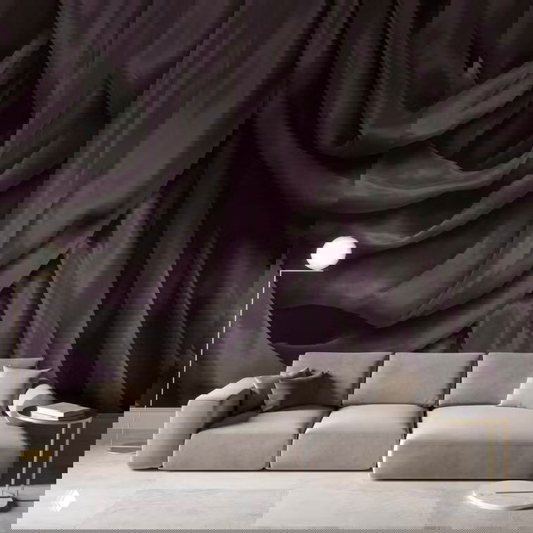 Интерьер с драпировкой на стене: обои, имитирующие складки ткани, тёмно‑фиолетовая драпировка на фоне светлого дивана и современного оформления комнаты.