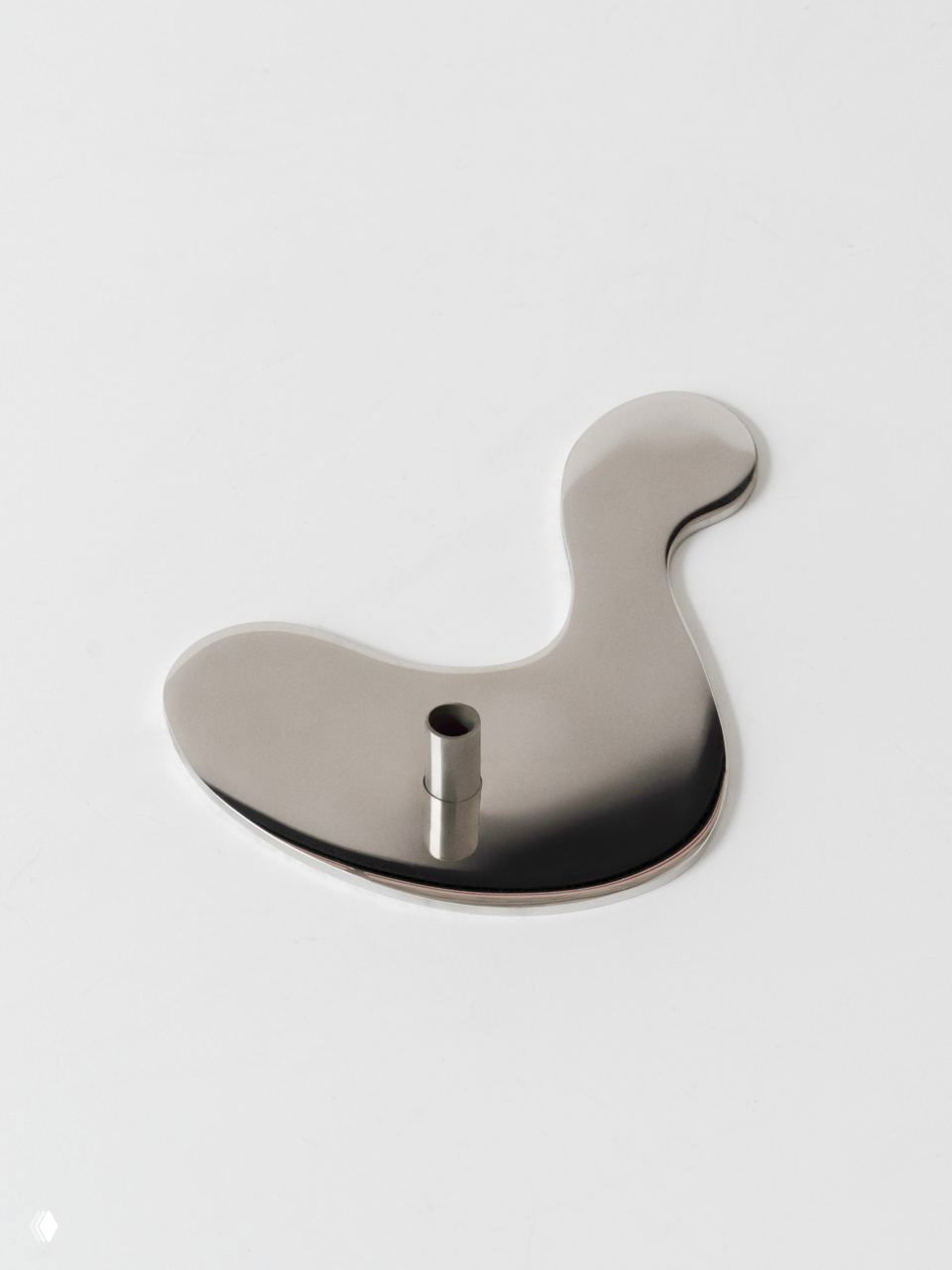 Крупный план зеркальной металлической подставки Puddle без свечи, акцент на отражающей поверхности, гладких краях и минималистичной форме изделия.