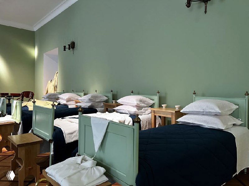 Повреждённое или искажённое изображение интерьера с рядами кроватей; фотография визуально искажена и нечитабельна.