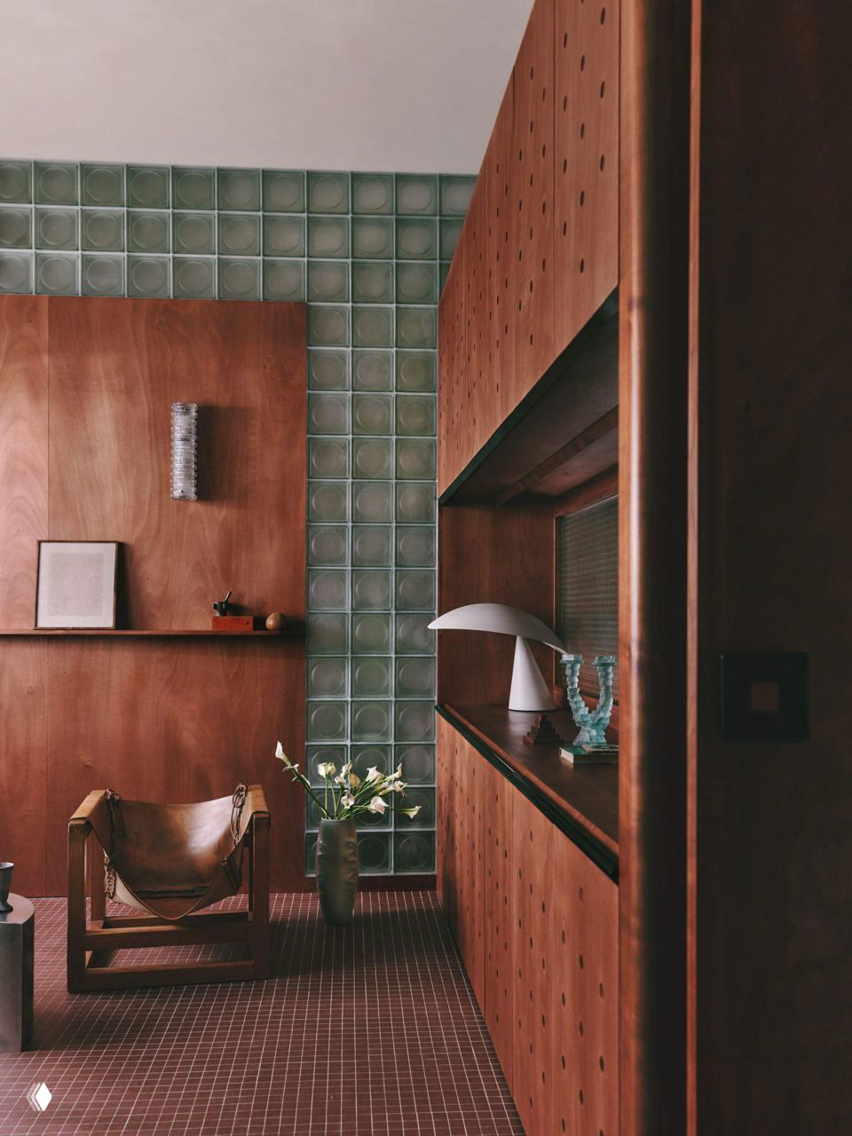 Кабинет в студии: отделка из красного дерева и стеклоблоки-перегородка, кожаное кресло и авторская подсветка создают тёплый интерьер.