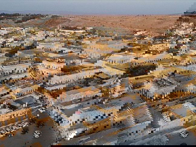 Аэрофотоснимок деревни Анытлы в провинции Мардин: плотная застройка из светлого камня, крыши и узкие улицы в историческом ландшафте.