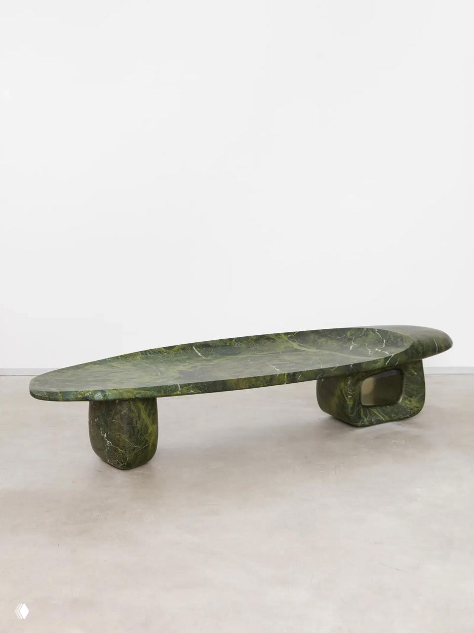 Низкий зелёный мраморный стол-скульптура на светлом фоне — примера скульптурной мебели, представленной на выставке Design Miami.Paris 2025.