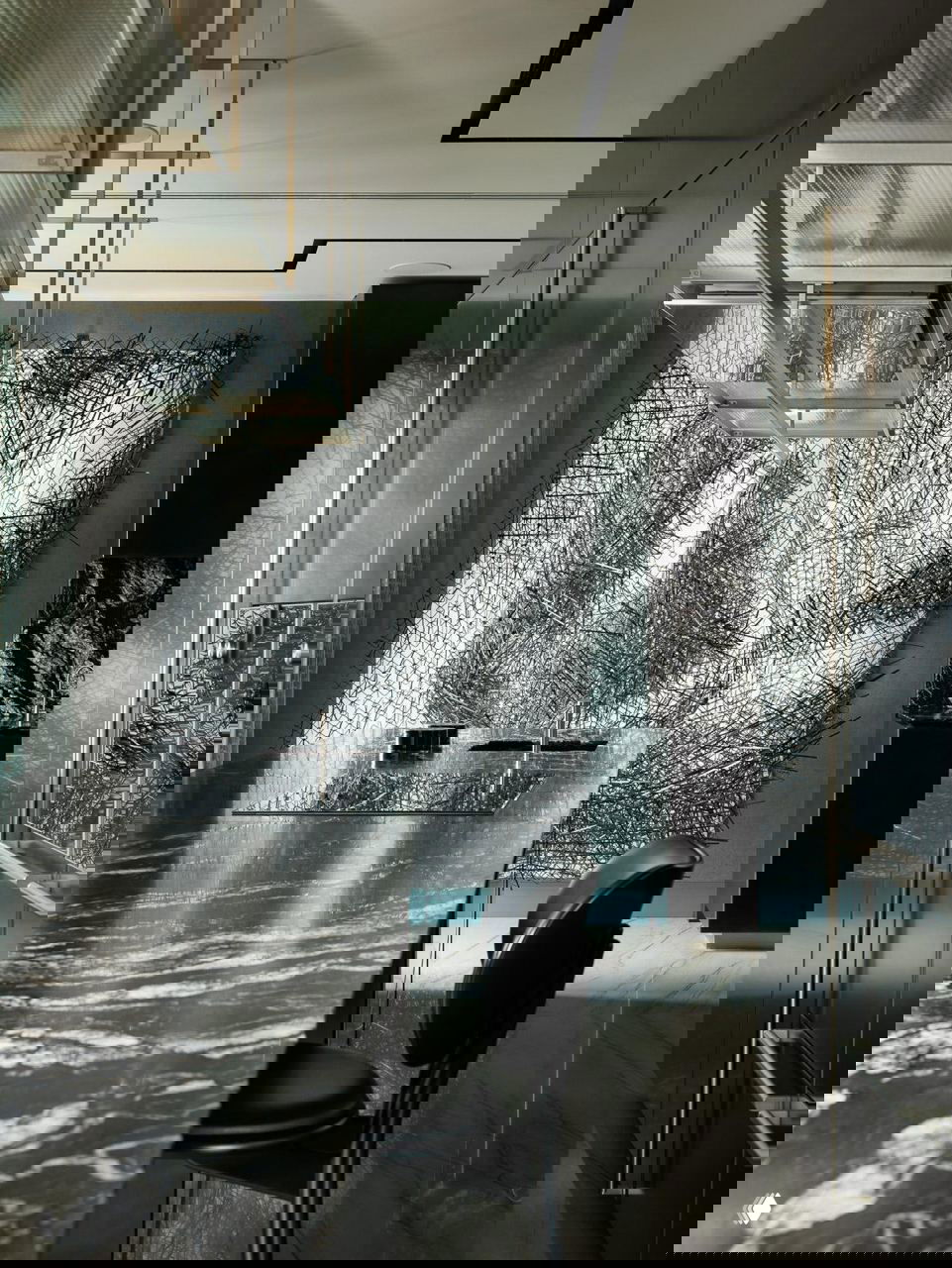 Современная кухонная зона с мраморной столешницей, чёрными барными стульями и крупным графичным художественным полотном у стены — минималистичный интерьер.