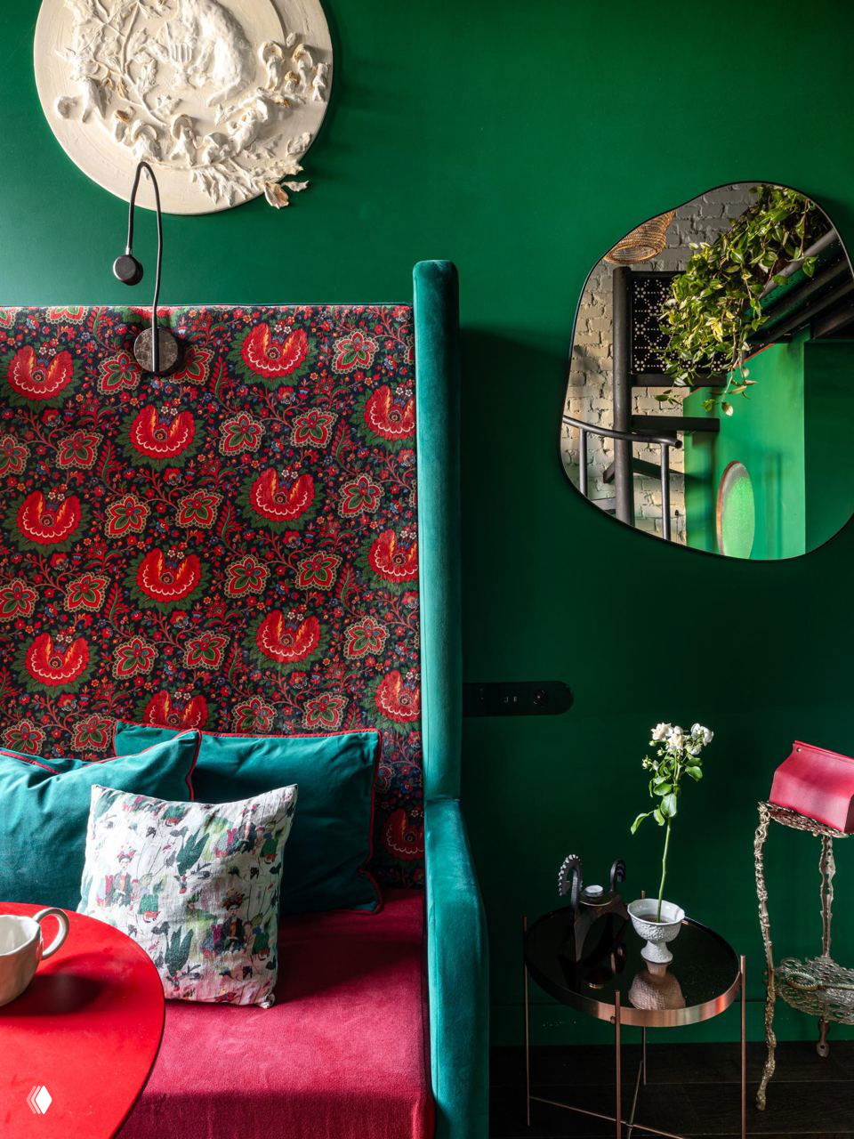 Комната с глубоким зелёным фоном, винно‑красной узорной обивкой и бархатным диваном — пример контраста винного и нефритового оттенков.