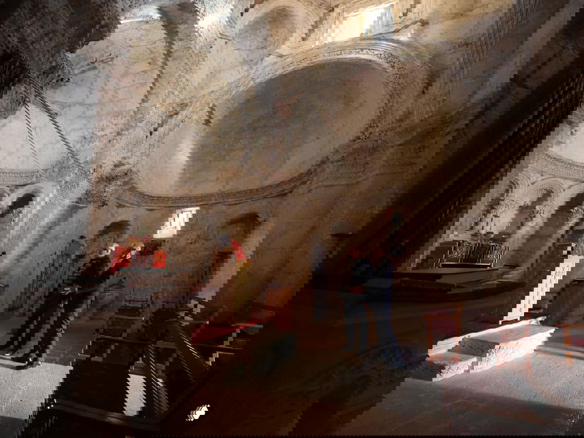 Интерьер древней церкви в Анытлы: купольные своды, арки и несколько посетителей внутри для масштаба и атмосферы места.