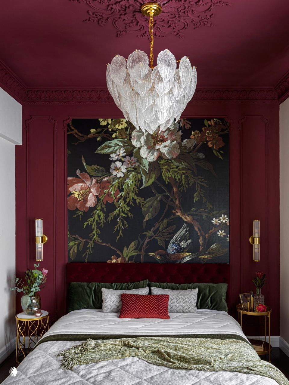 Спальня с насыщенно‑винной отделкой, крупной растительной росписью и зелёными акцентами в подушках и изголовье — драматичный интерьерный приём.