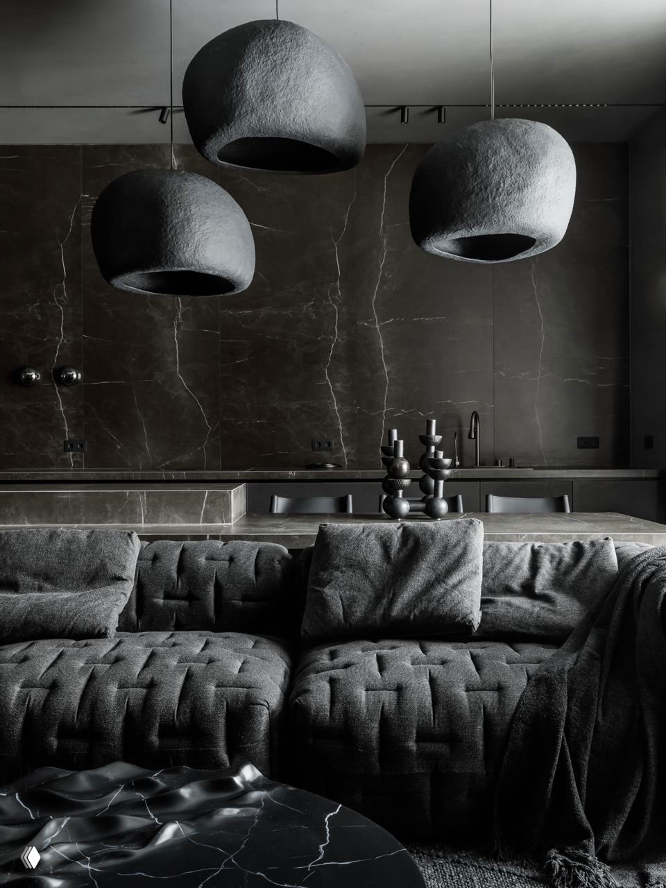 Темный интерьер-лофт с глубокими черными фактурами и висящими сферическими светильниками; видна минималистичная кухня без верхних шкафов.