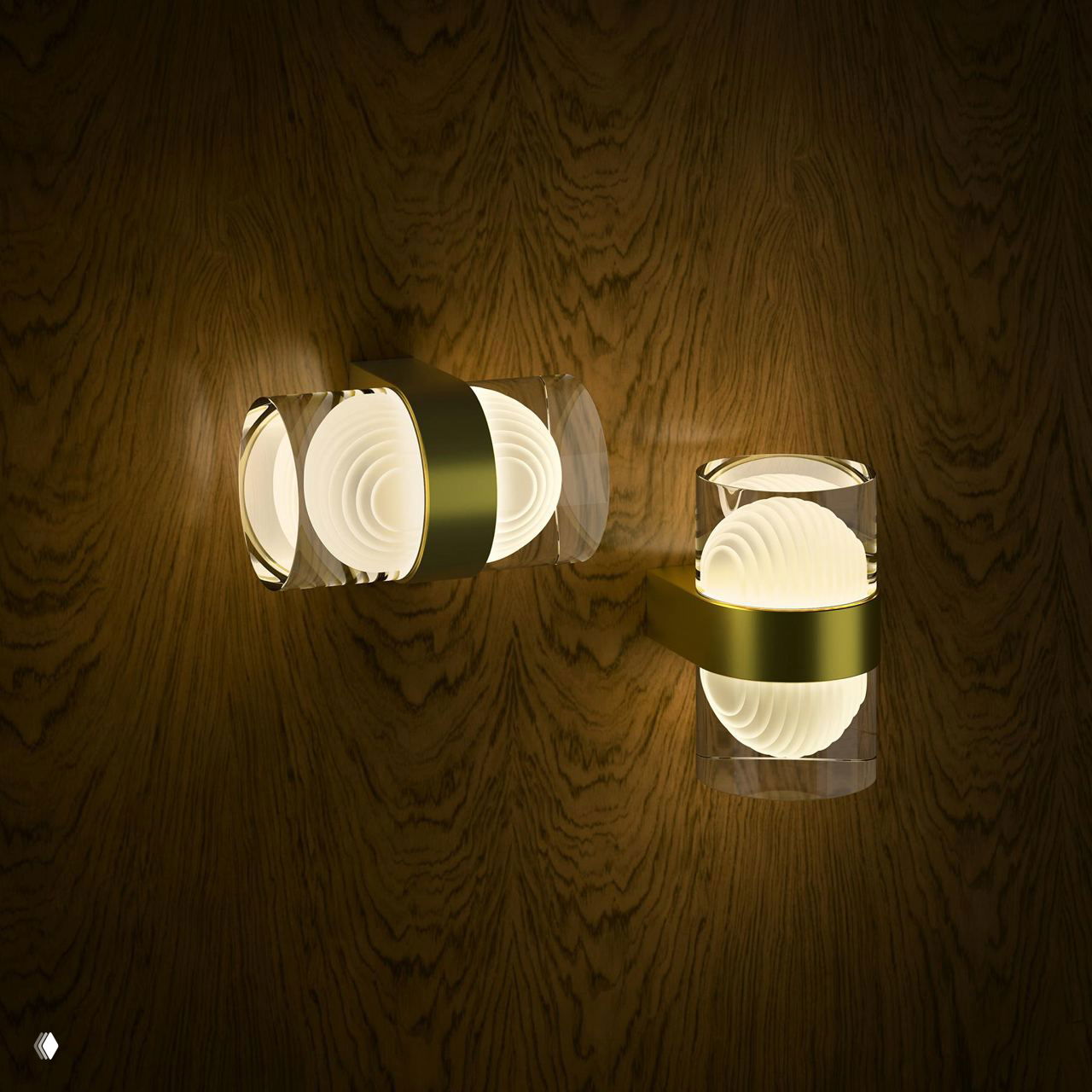 Две настенные цилиндрические лампы с прозрачными корпусами и золотыми держателями на деревянной стене; свет формирует мягкие круги и тёплые блики.