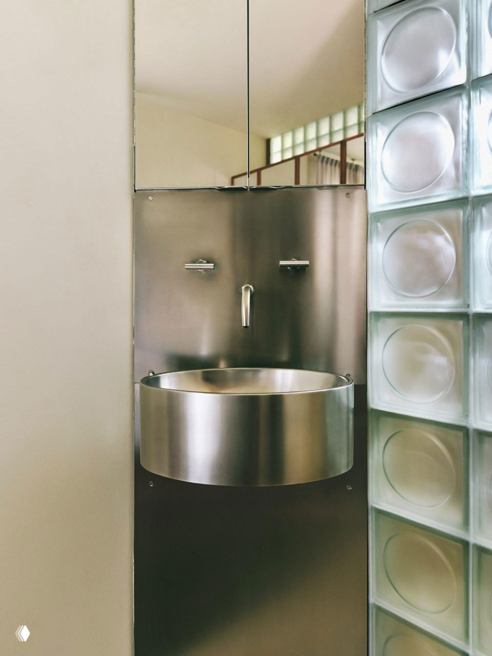 Общий вид интерьера студии: сочетание красного дерева, матовых стеклоблоков и сдержанных текстур создаёт спокойную атмосферу.