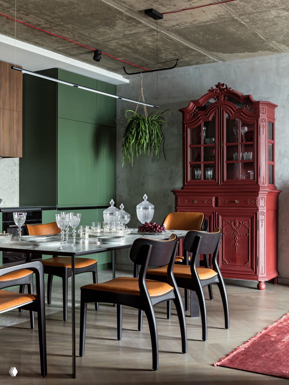 Столовая с зелёными кухонными фасадами и массивным винно‑красным буфетом, сочетание антиквариата и современного дизайна.