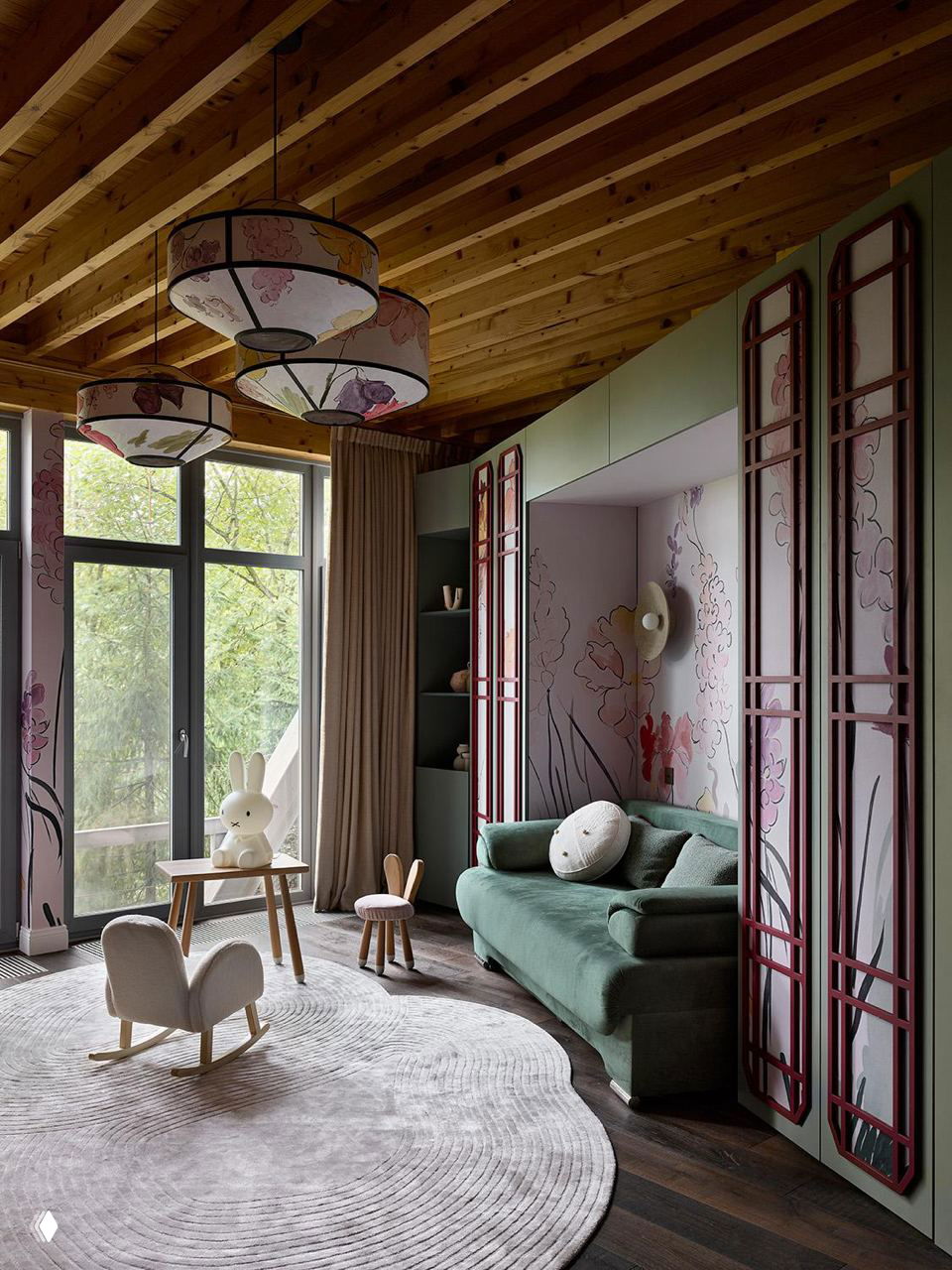 Детская комната с зелёным диваном, декоративными панелями и высоким окном, мягкий круглый ковёр и деревянный потолок; проект в Подмосковье.
