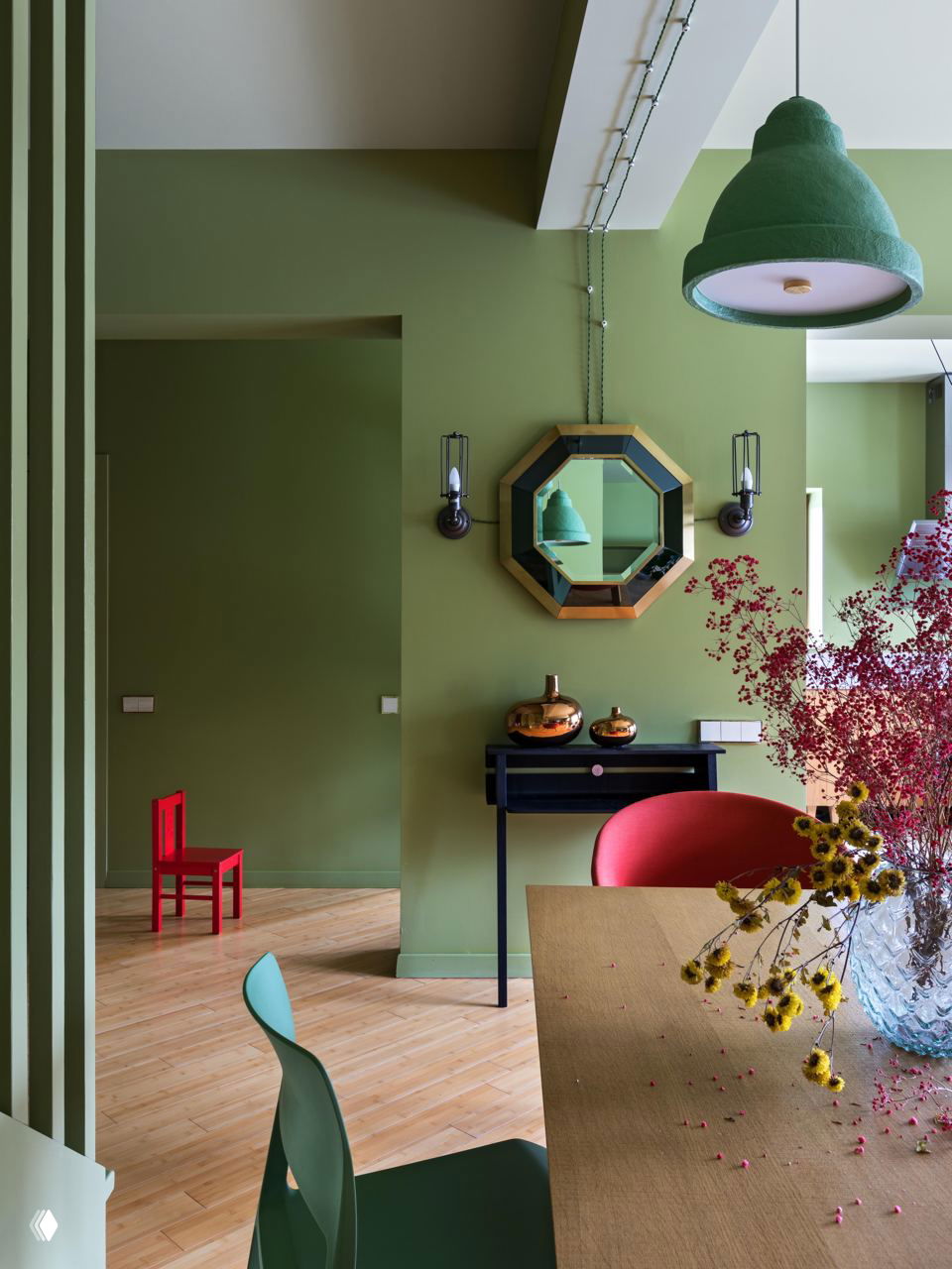 Светлая комната с пастельно‑зелёными стенами и яркими красными предметами мебели — пример мягкого, но насыщенного дуэта цветов в интерьере.