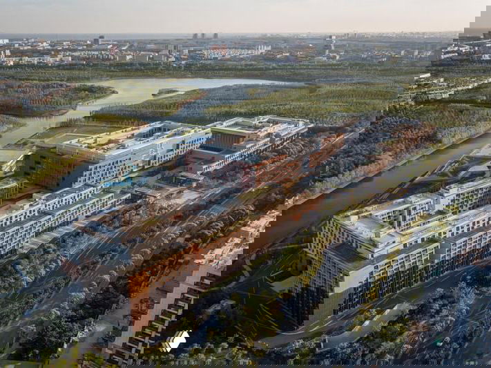 Вид с воздуха на кампус в районе Линьган (Шанхай): компактные учебные корпуса у воды, зелёные зоны и городская инфраструктура вокруг.