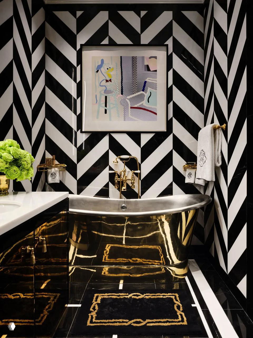 Ванная или санузел с чёрно-белой зигзагообразной плиткой и блестящей золотой отдельно стоящей ванной, роскошные аксессуары.