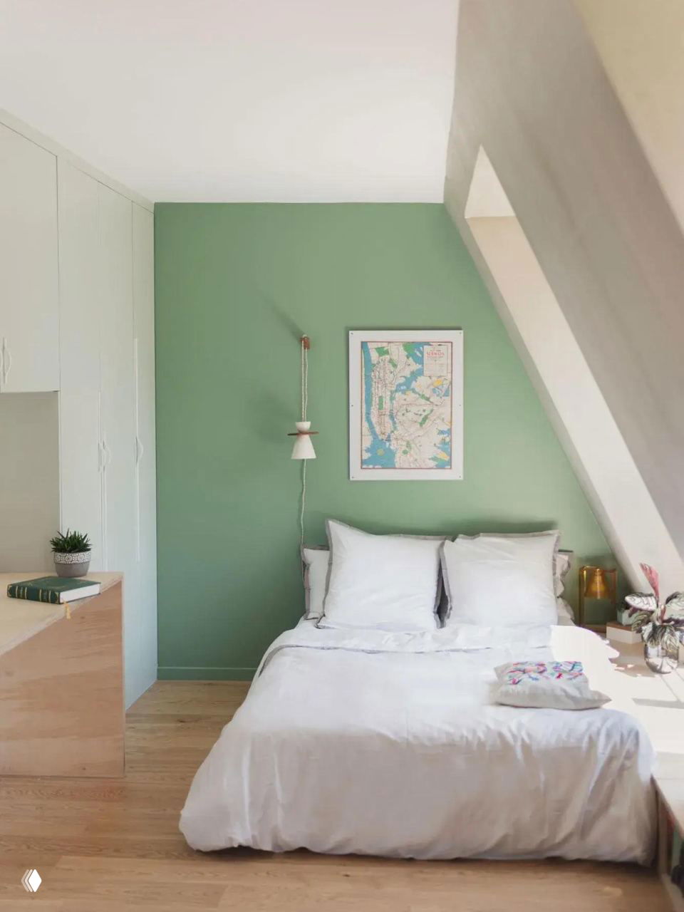 Светлая спальня с зелёной акцентной стеной: простое текстильное оформление, белое постельное бельё и аккуратные встроенные шкафы.