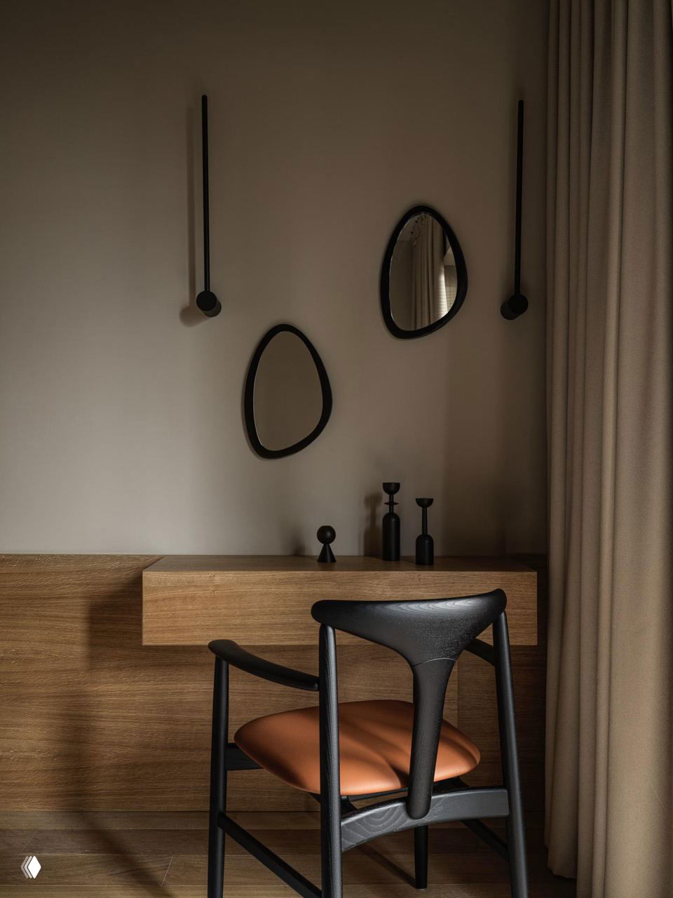 Рабочий или гримировочный уголок с деревянной тумбой, дизайнерским креслом с кожаной подушкой и овальными зеркалами на стене, приглушённое освещение.